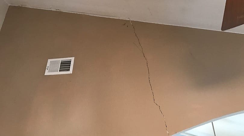 Crack running down interior drywall beside an air vent