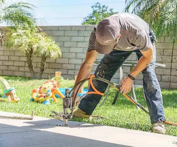 Dalinghaus technician lifting a settled concrete walkway with polyurethane injection in a back garden