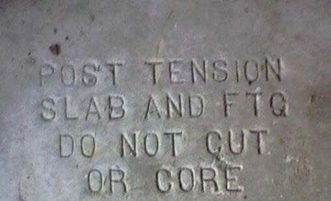 Warning stamped into a concrete slab: post tension slab and footing, do not cut or core