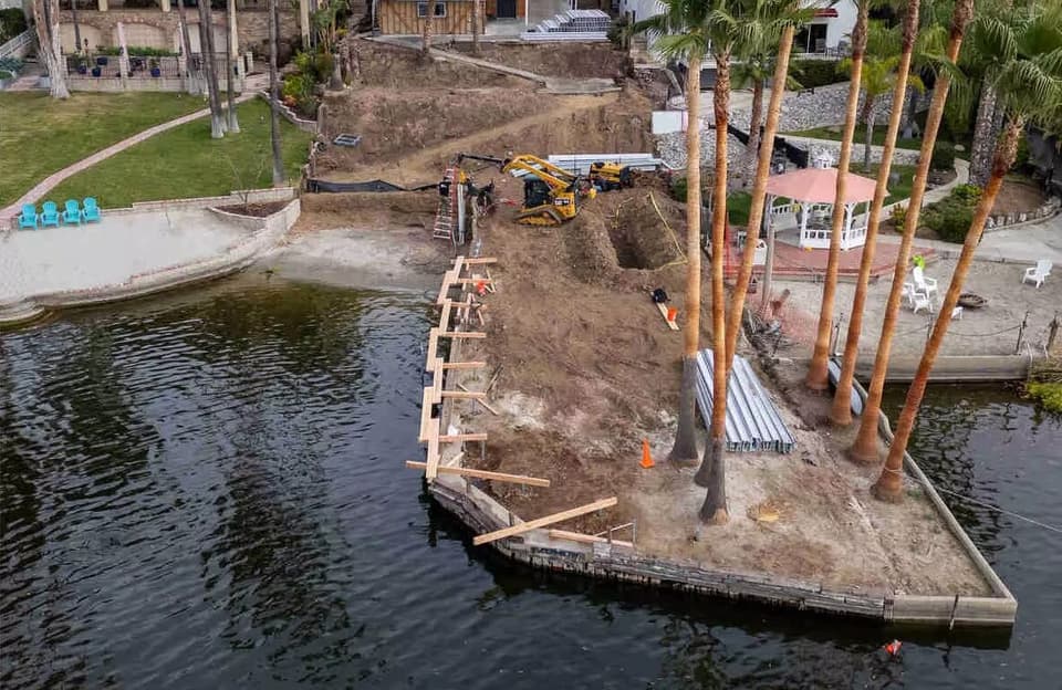 Dalinghaus Foundation Repair crew performing seawall construction and anchoring with an excavator.