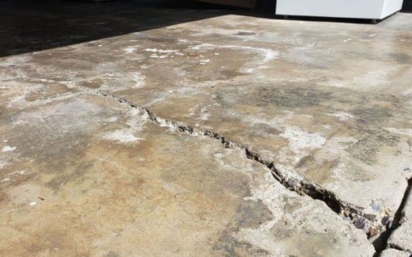 Dalinghaus Foundation Repair inspecting severe concrete cracking and a sunken concrete slab.