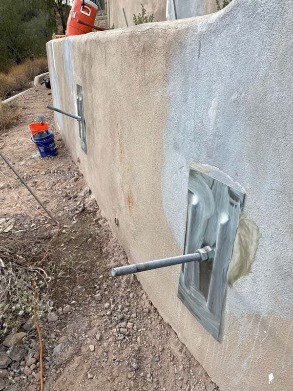 Dalinghaus Foundation Repair installing tieback anchors for retaining wall reinforcement.