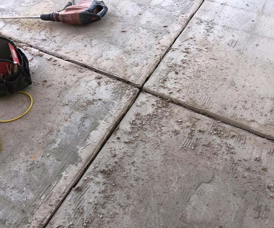 Dalinghaus Foundation Repair addressing cracking expansion joints in concrete slabs with a jackhammer.