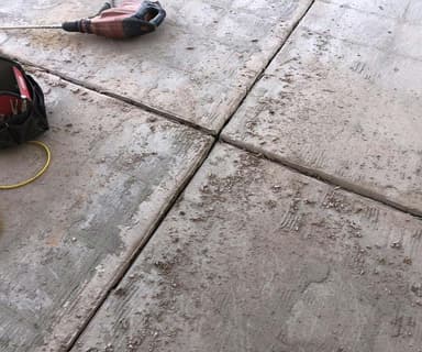 Dalinghaus Foundation Repair addressing cracking expansion joints in concrete slabs with a jackhammer.