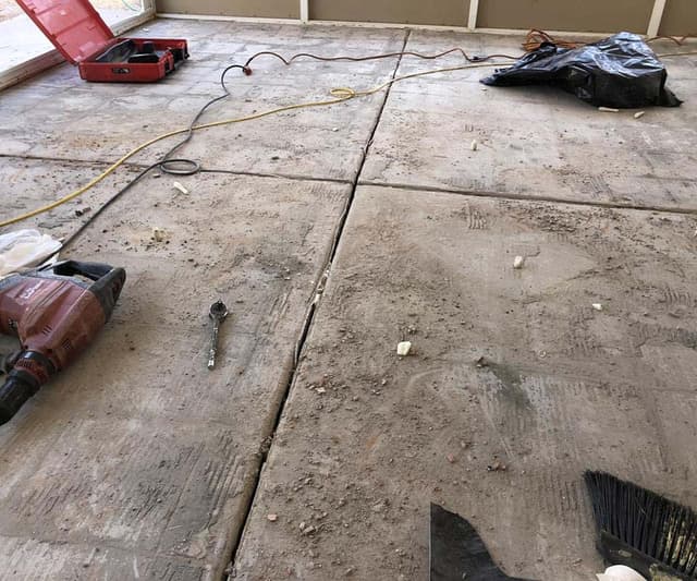 Dalinghaus Foundation Repair crew repairing cracking expansion joints in a concrete slab using a jackhammer.