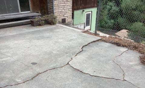 Dalinghaus Foundation Repair repairing an uneven concrete patio slab with concrete cracking at a residential exterior.