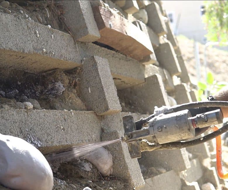 Dalinghaus Foundation Repair performing polyurethane injection for void filling in a concrete block retaining wall.