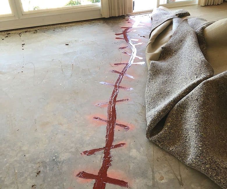 Dalinghaus Foundation Repair preparing a concrete floor crack for epoxy injection.