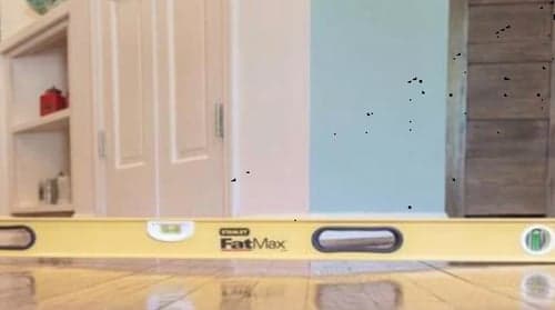 Dalinghaus Foundation Repair using a level tool to inspect for uneven floors in a home interior.