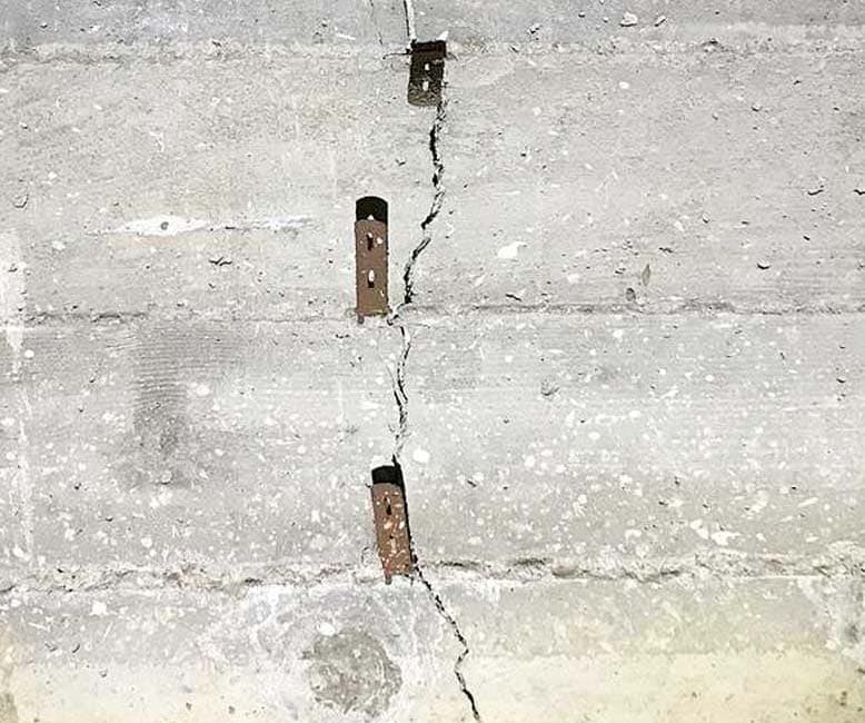 Dalinghaus Foundation Repair repairing a vertical crack in a concrete wall with metal form ties