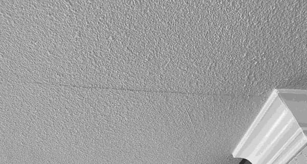 Dalinghaus Foundation Repair inspecting hairline cracks in ceiling drywall.
