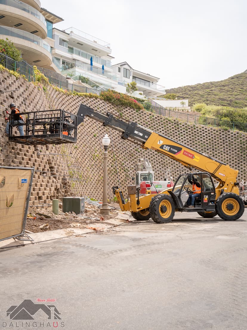 Dalinghaus Foundation Repair crew installing tieback anchors to stabilize a large residential retaining wall.
