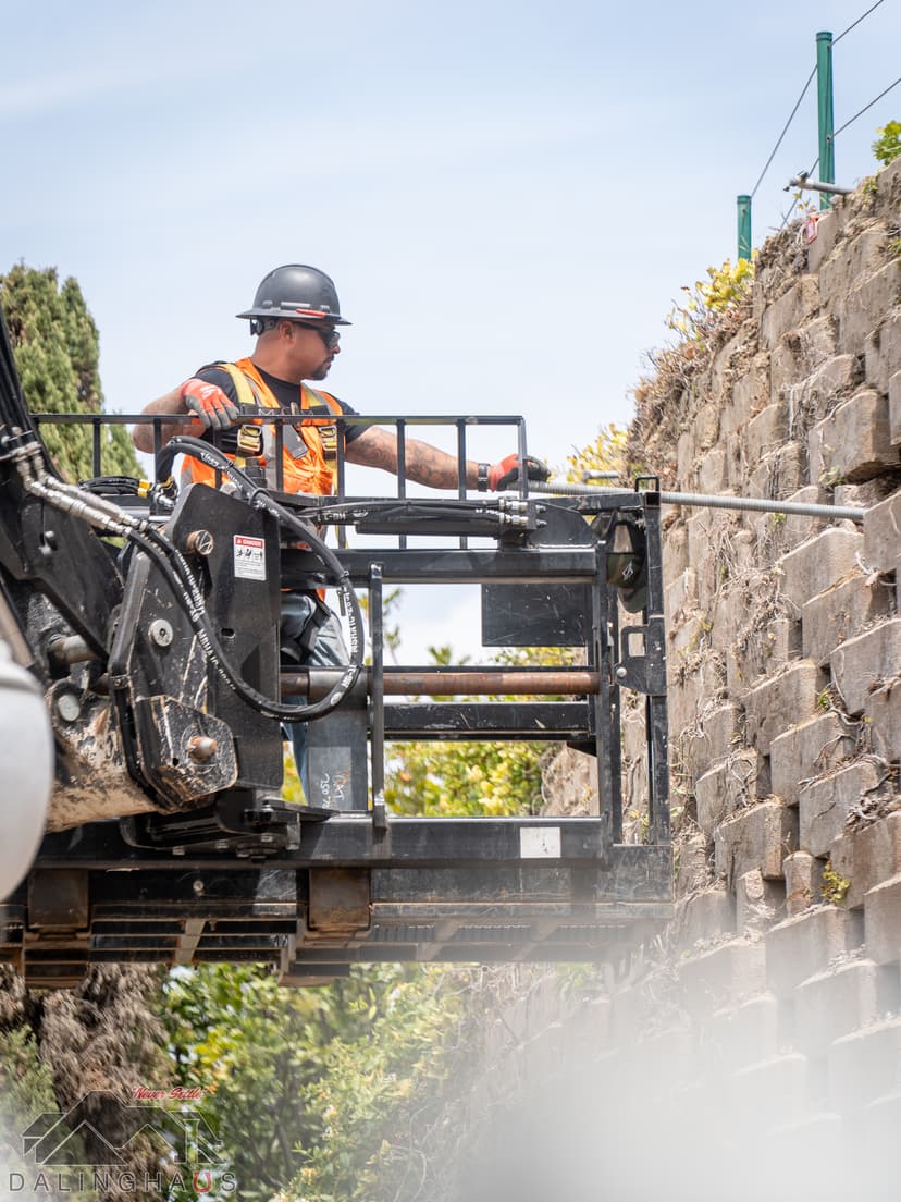 Dalinghaus Foundation Repair crew drilling tieback anchors for retaining wall repair in Dana Point.