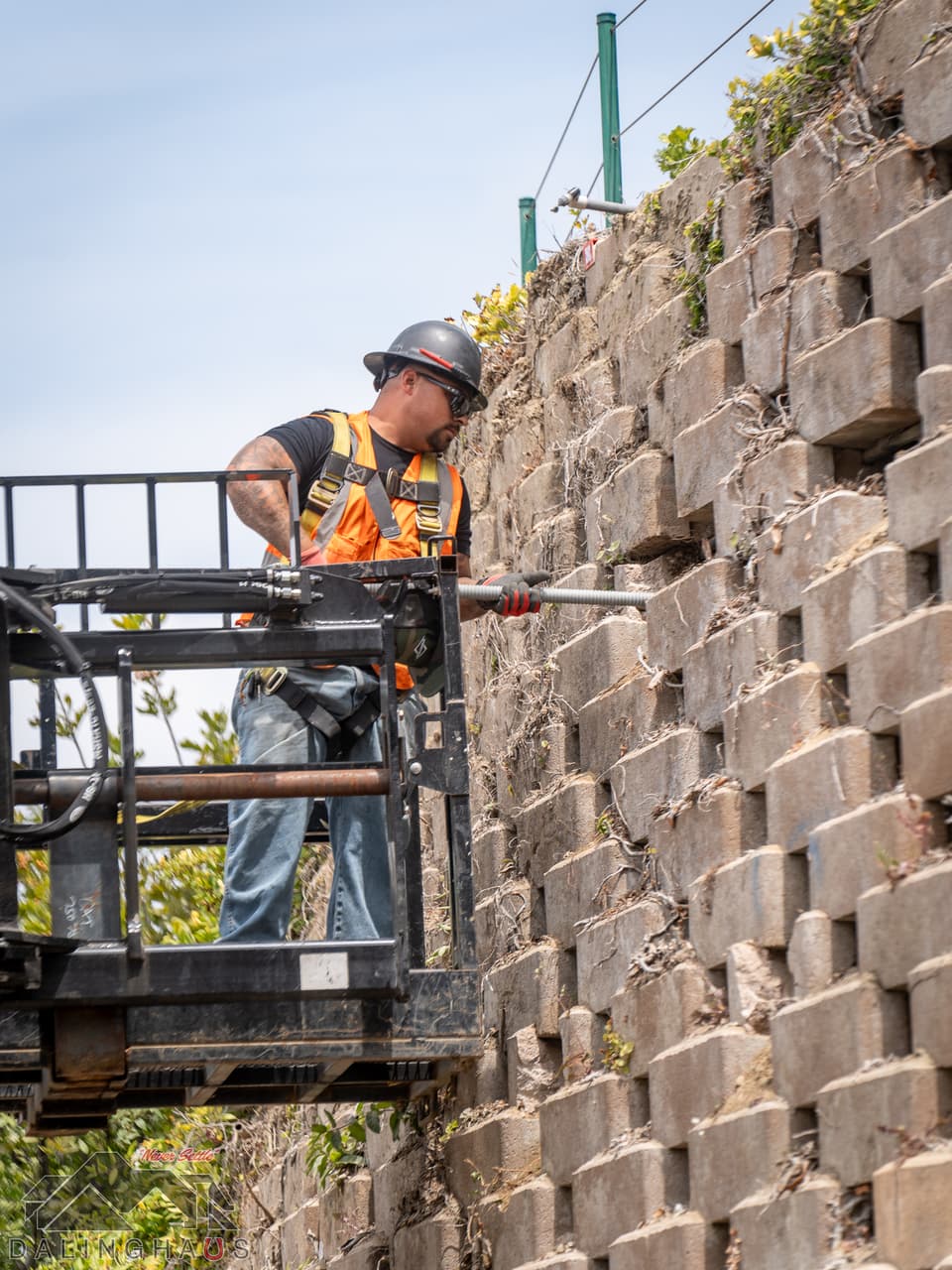 Dalinghaus Foundation Repair crew installing retaining wall anchoring systems into a retaining wall.