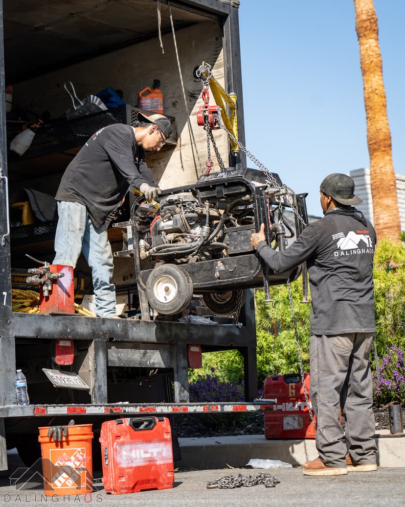 Dalinghaus Foundation Repair crew unloading a hydraulic power unit from a service truck at a job site.