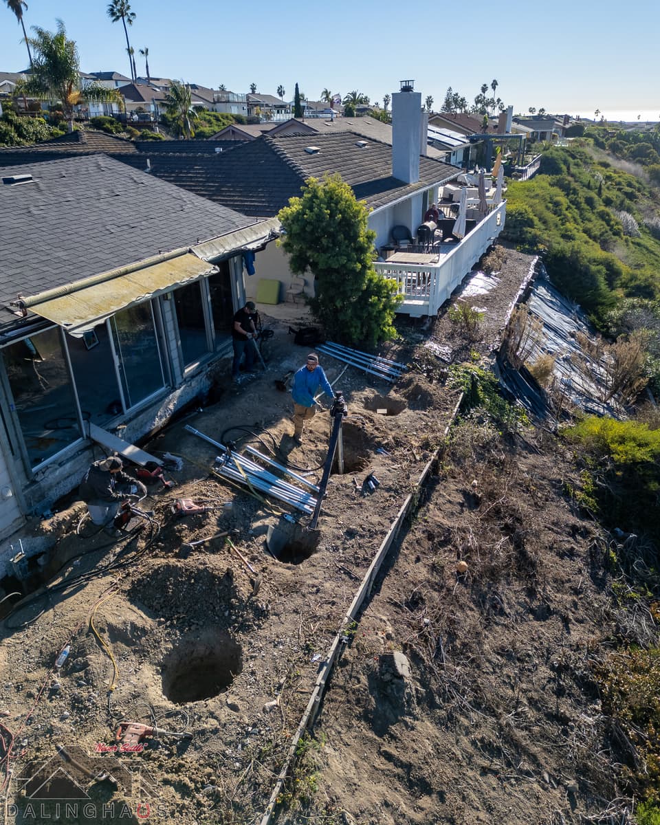 Dalinghaus Foundation Repair crew installing steel piers for foundation underpinning on a hillside home in San Clemente.