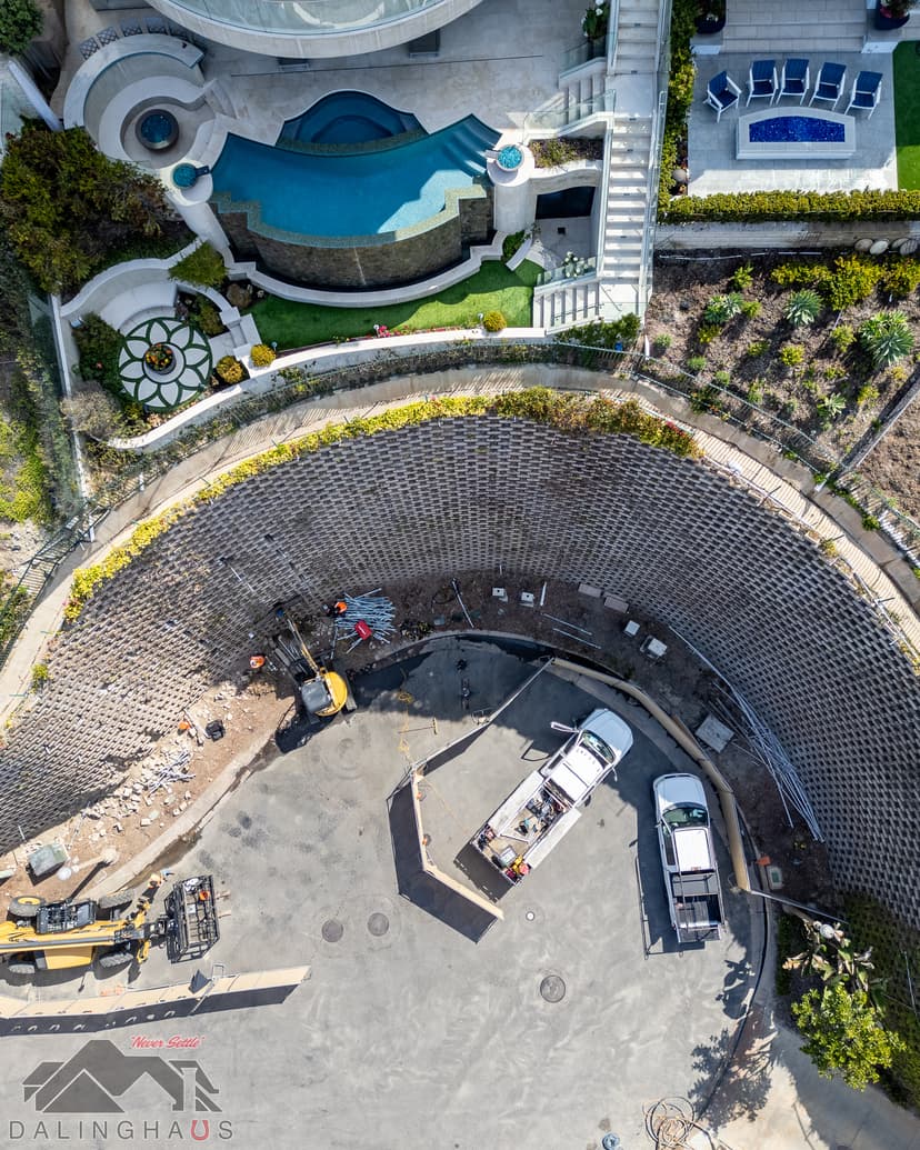 Dalinghaus Foundation Repair crew with excavators installing structural reinforcement wall anchor systems for retaining wall