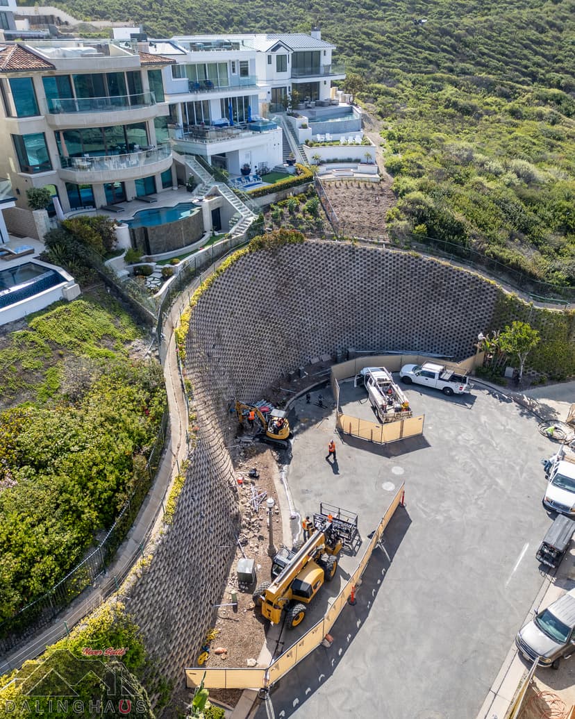 Dalinghaus Foundation Repair crew with heavy equipment performing retaining wall repair in Dana Point.