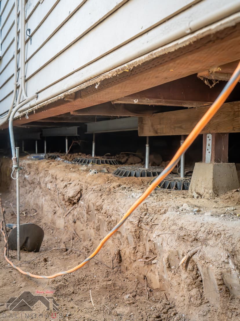 Dalinghaus Foundation Repair installing adjustable steel support jacks in a crawl space foundation.