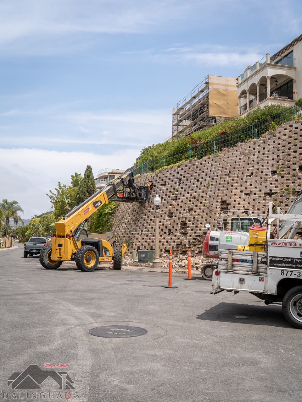 Dalinghaus Foundation Repair crew using a telehandler to work on a failing retaining wall in Dana Point.