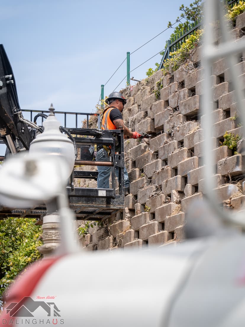 Dalinghaus Foundation Repair crew member in a man lift repairing a retaining wall with wall stabilization systems.