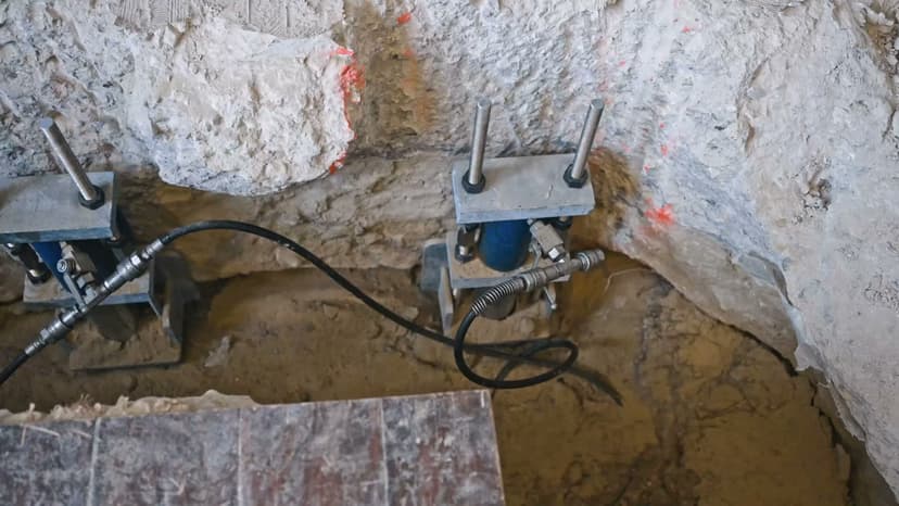 Dalinghaus Foundation Repair installing steel piers for foundation underpinning with hydraulic equipment in excavated soil.