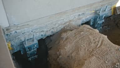 Dalinghaus Foundation Repair installing steel pier foundation underpinning with foundation brackets and excavation.