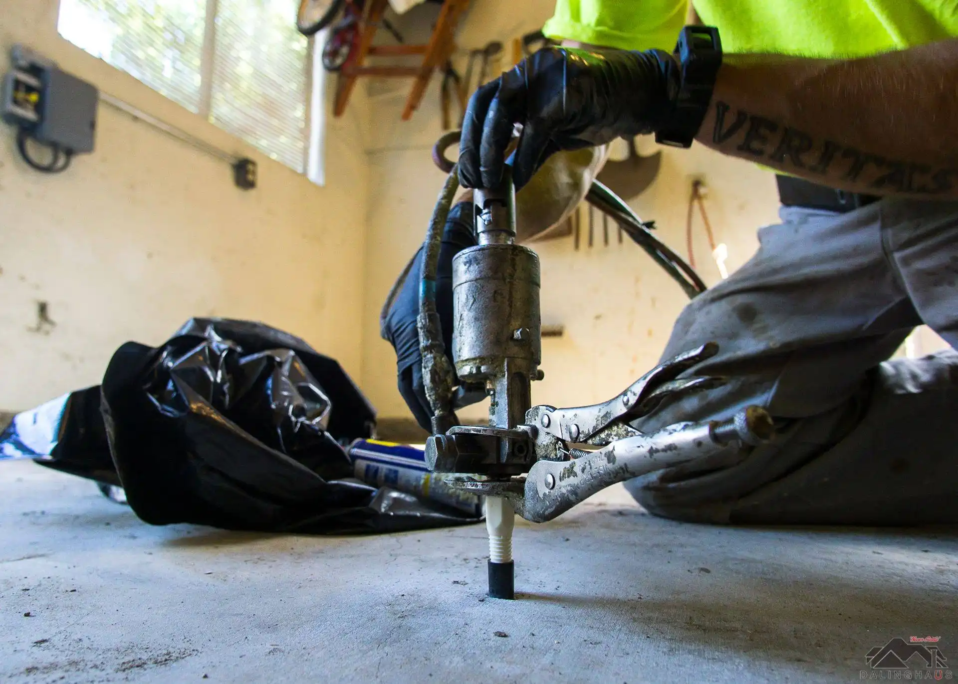 Dalinghaus Foundation Repair technician installing an injection port for polyurethane crack repair in a garage floor.
