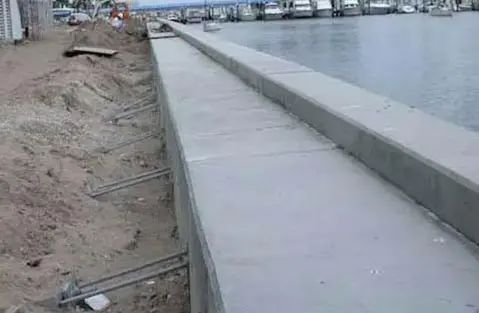 Dalinghaus Foundation Repair crew installing new seawall anchoring and concrete cap in a harbor.