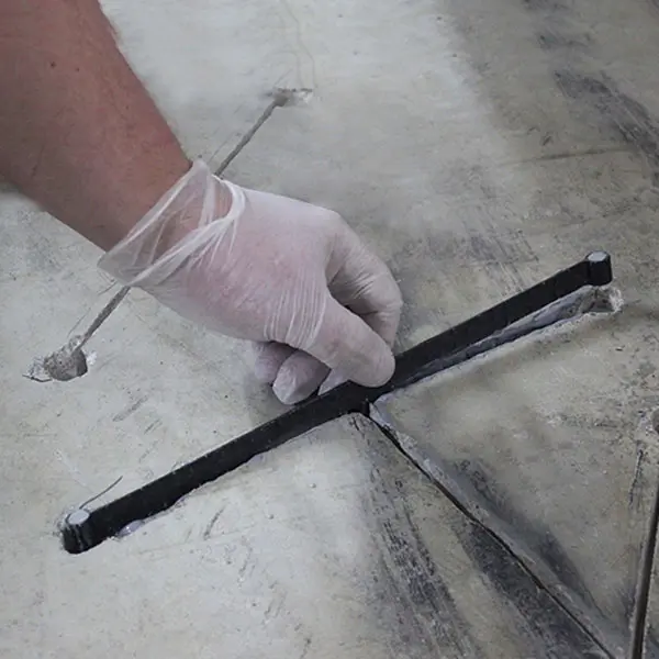 Dalinghaus Foundation Repair worker injecting epoxy into a carbon fiber reinforced floor crack.