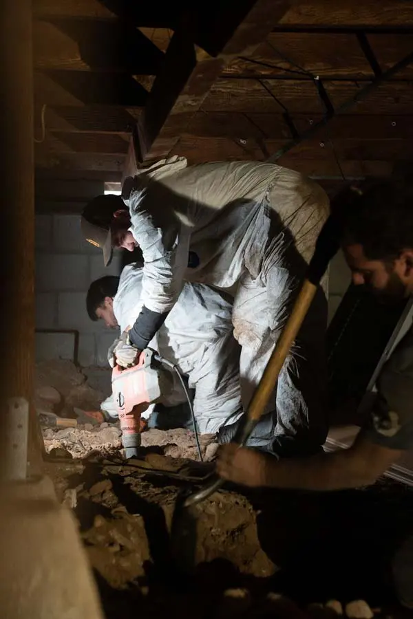 Dalinghaus Foundation Repair crew using a jackhammer and shovels for crawl space structural excavation.