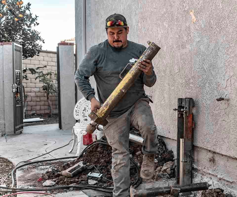 Dalinghaus Foundation Repair technician installing push piers using a hydraulic drive stand.