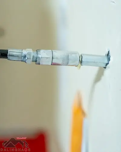Dalinghaus Foundation Repair injecting polyurethane foam into a concrete wall crack through an injection port.