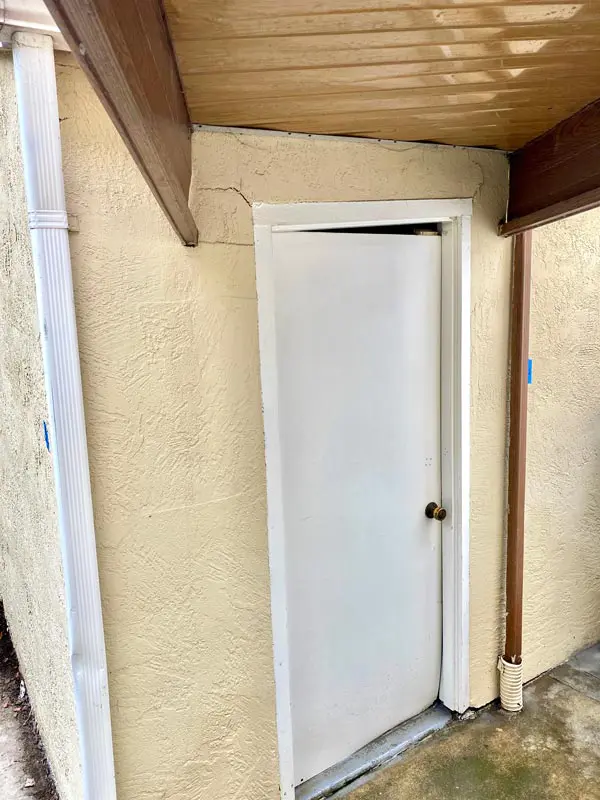 Dalinghaus Foundation Repair inspecting stucco cracking and a gap between the door and frame.