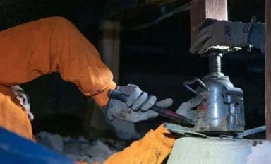 Dalinghaus Foundation Repair crew installing an adjustable smart jack for sagging floor repair in a crawl space.