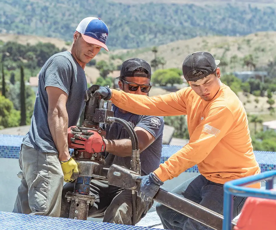 Dalinghaus Foundation Repair crew installing a helical pier system for pool deck leveling and stabilization.