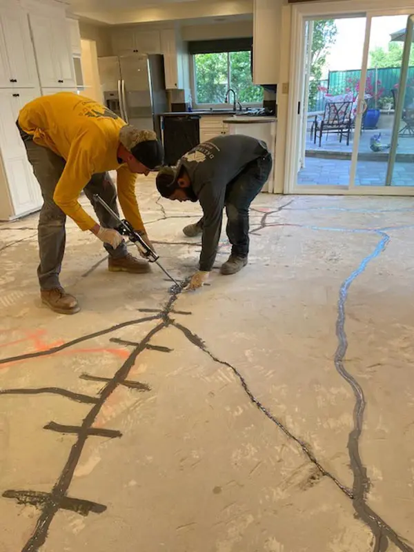 Dalinghaus Foundation Repair crew performing concrete crack injection on an interior slab floor.
