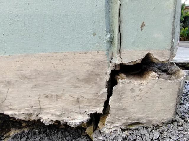 Dalinghaus Foundation Repair assessing a concrete stem wall with spalling, deep cracks, and shattered sections.