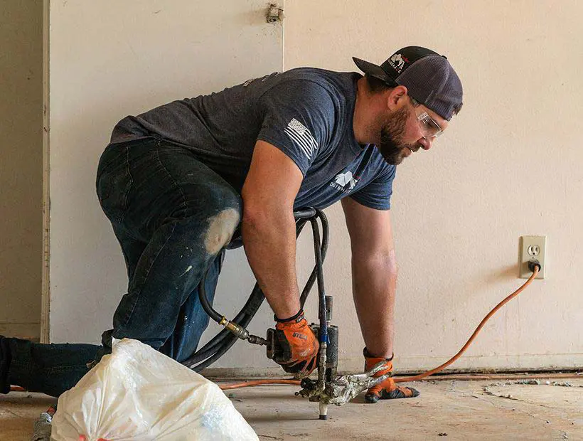 Dalinghaus Foundation Repair technician drilling interior concrete slab for polyurethane foam injection.