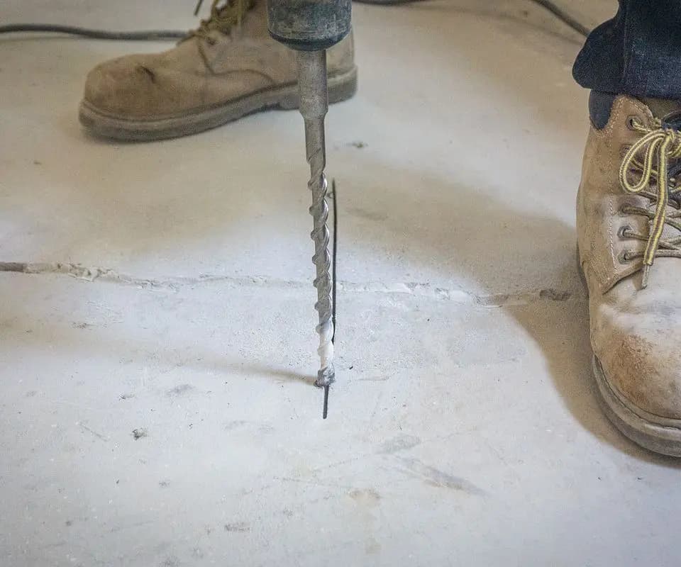 Dalinghaus Foundation Repair drilling into a cracked concrete slab for polyjacking service.