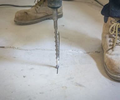 Dalinghaus Foundation Repair drilling into a cracked concrete slab for polyjacking service.