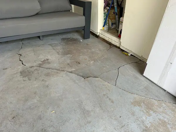 Dalinghaus Foundation Repair inspecting significant cracked garage floor with concrete slab damage.