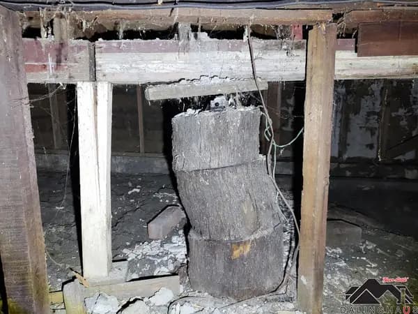 Dalinghaus Foundation Repair shows a crawl space before structural repair, with sagging floor joists and a rotted stump post.