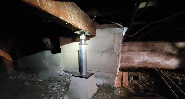 Dalinghaus Foundation Repair is installing an adjustable jacks to support a sagging crawl space beam.