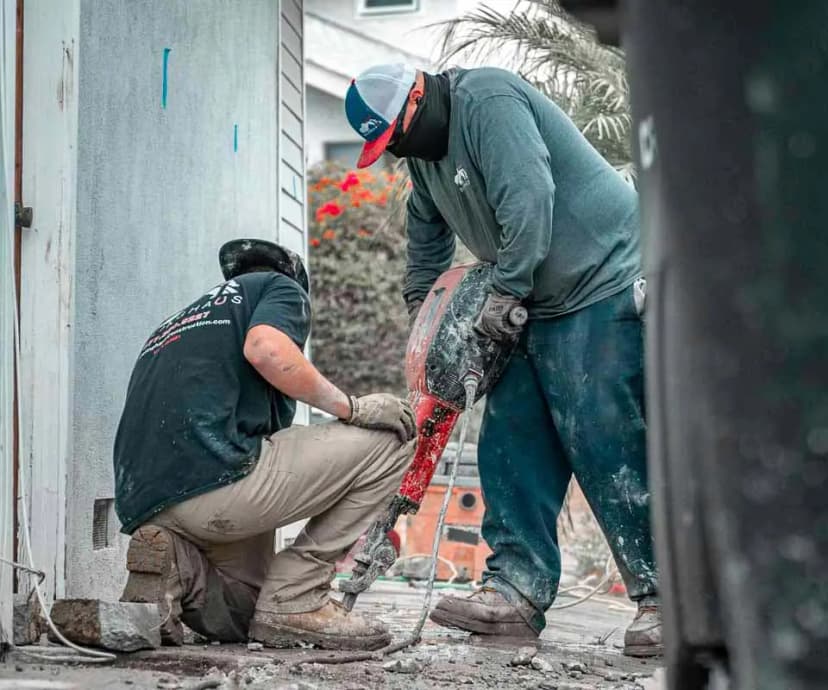 Dalinghaus Foundation Repair crew jackhammering concrete at a foundation for repair.