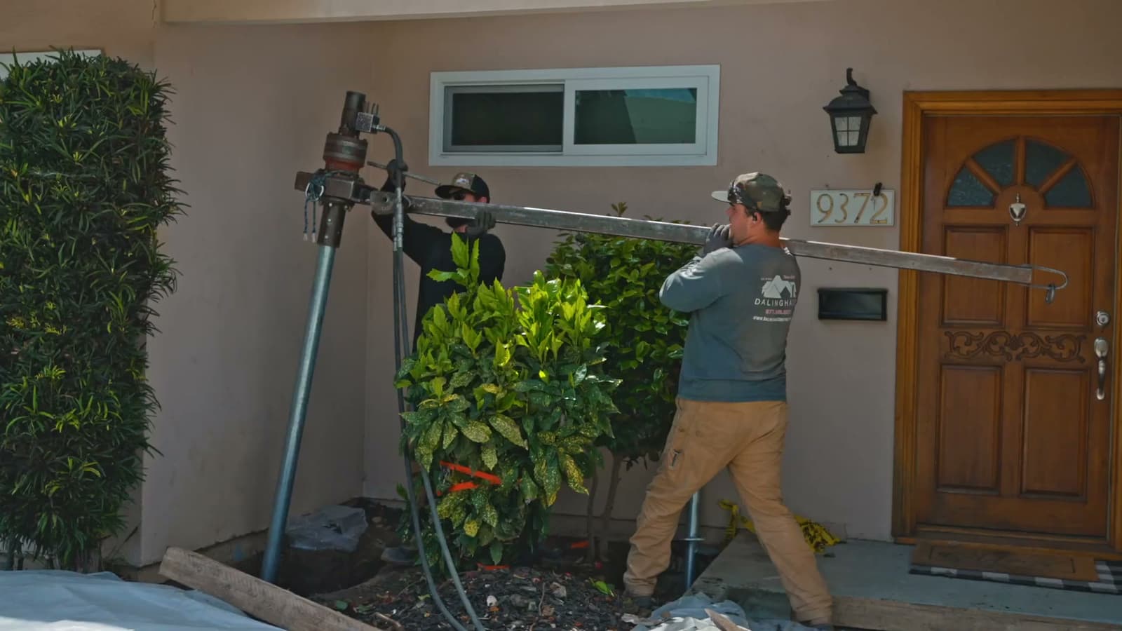 Dalinghaus Foundation Repair crew installing helical piers with a rotary drive head on a residential foundation in La Habra.