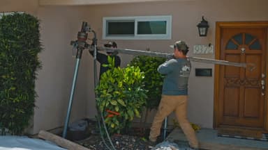 Dalinghaus Foundation Repair crew installing helical piers with a rotary drive head on a residential foundation in La Habra.