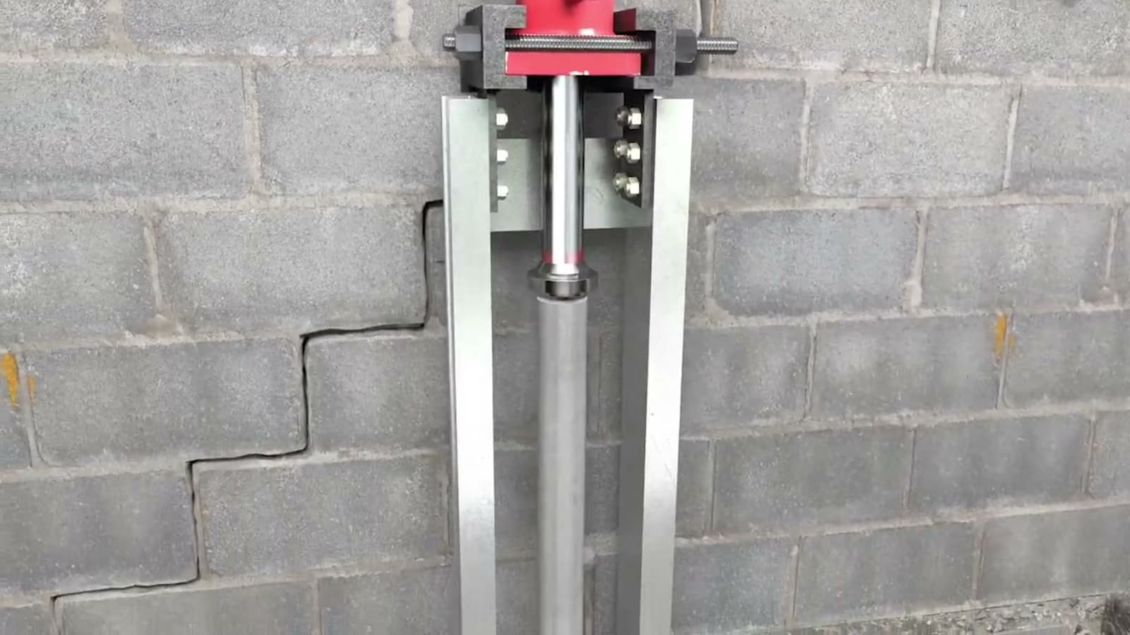 Dalinghaus Foundation Repair installing push piers with a hydraulic ram, for bowing concrete block walls with a stair-step