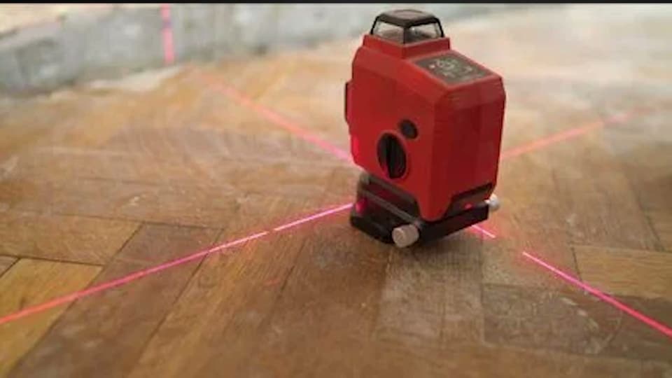 Dalinghaus Foundation Repair technician using a laser level to measure floor settling for concrete leveling.