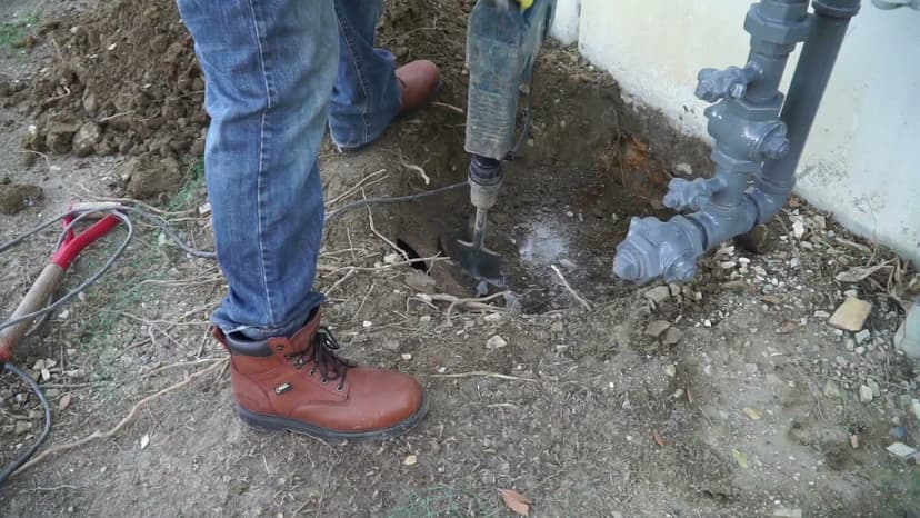 Dalinghaus Foundation Repair technician using a jackhammer for excavation in Diamond Bar, preparing a foundation repair site.